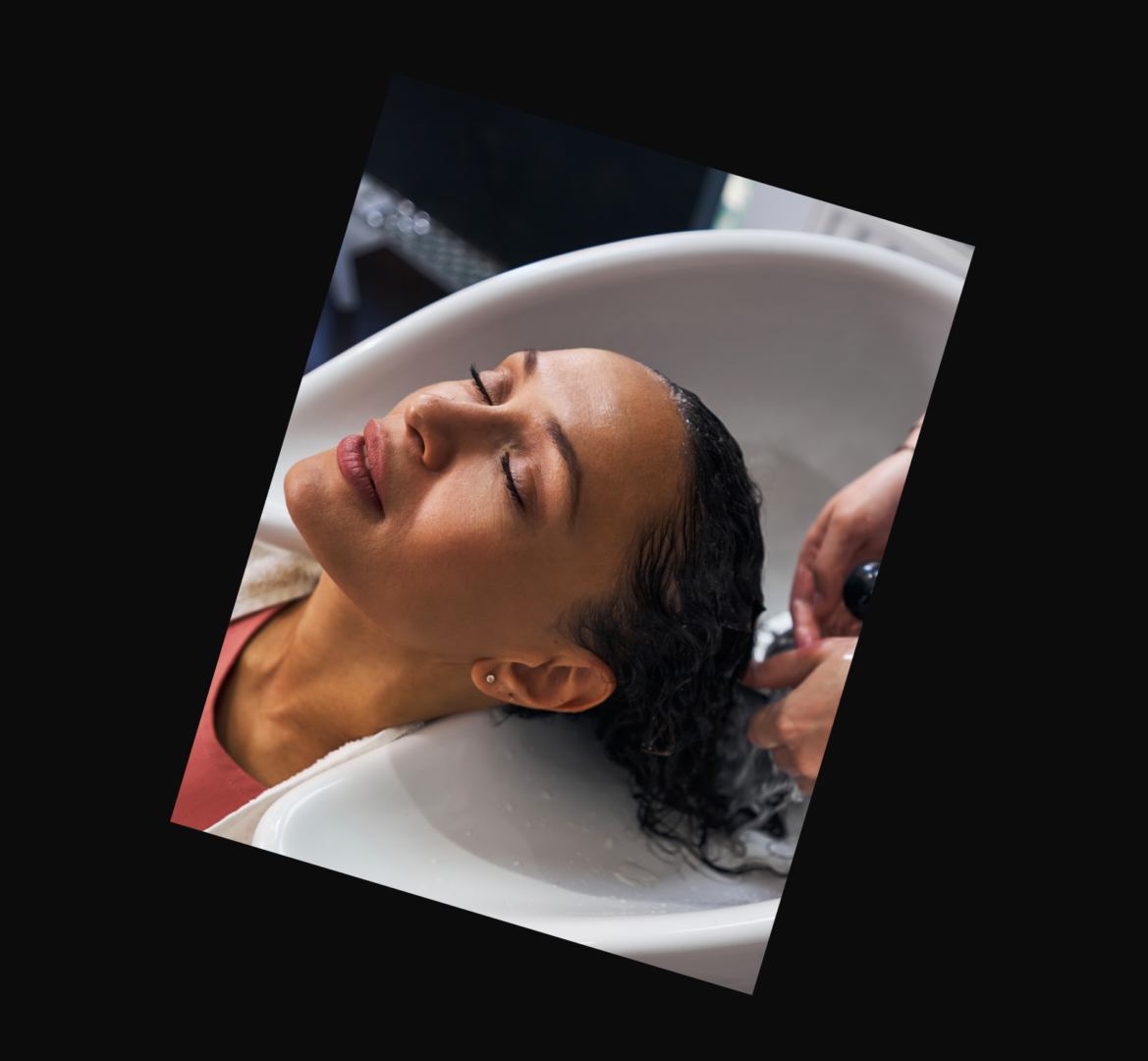 29 A woman getting her hair washed in the sink.