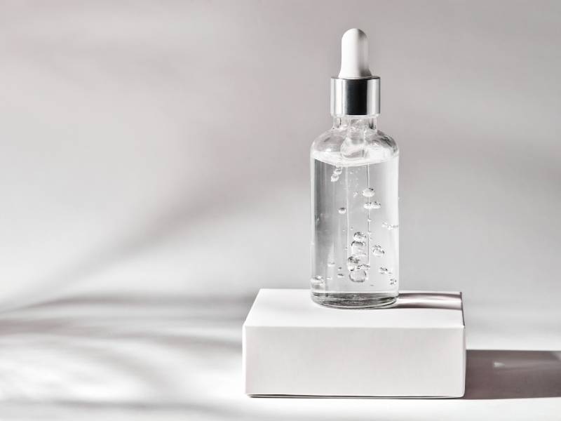 A bottle of liquid sitting on top of a white box.