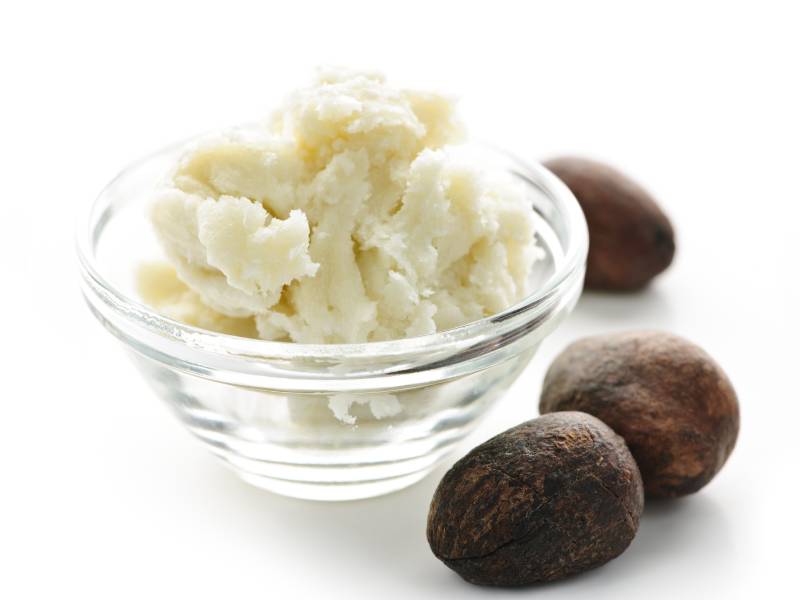 A bowl of mashed potatoes next to three nuts.