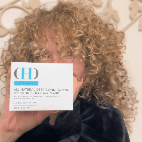 Person holding a hair mask product box.