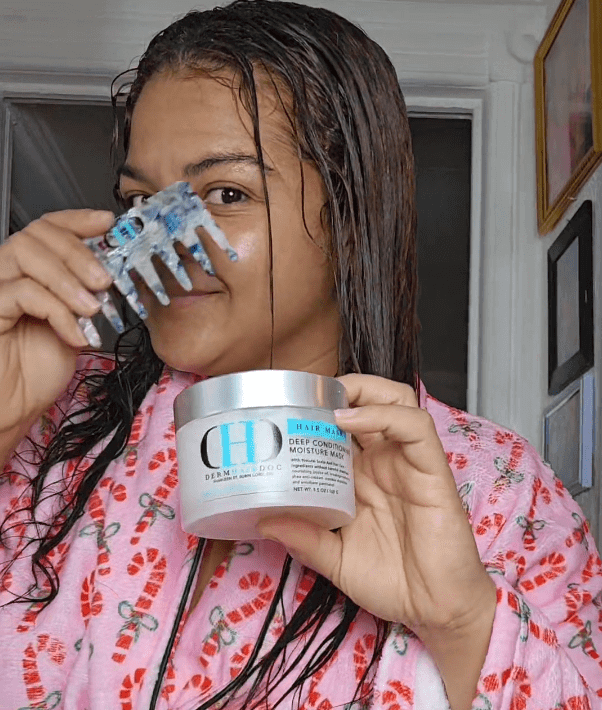 Person holding hair product and comb.