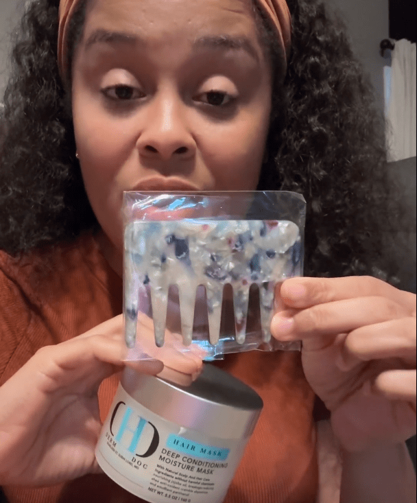 Woman holding hair mask and comb.