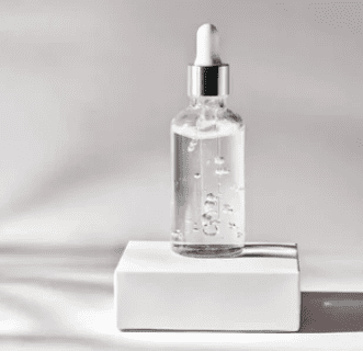 Glass dropper bottle on white box.