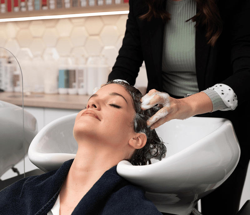 Woman receiving hair wash at salon.