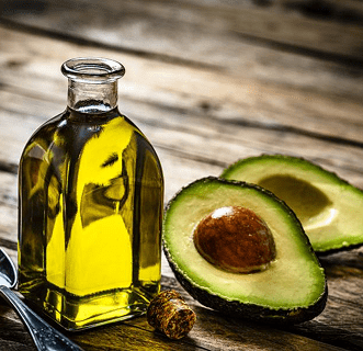 Avocado oil bottle with sliced avocado.